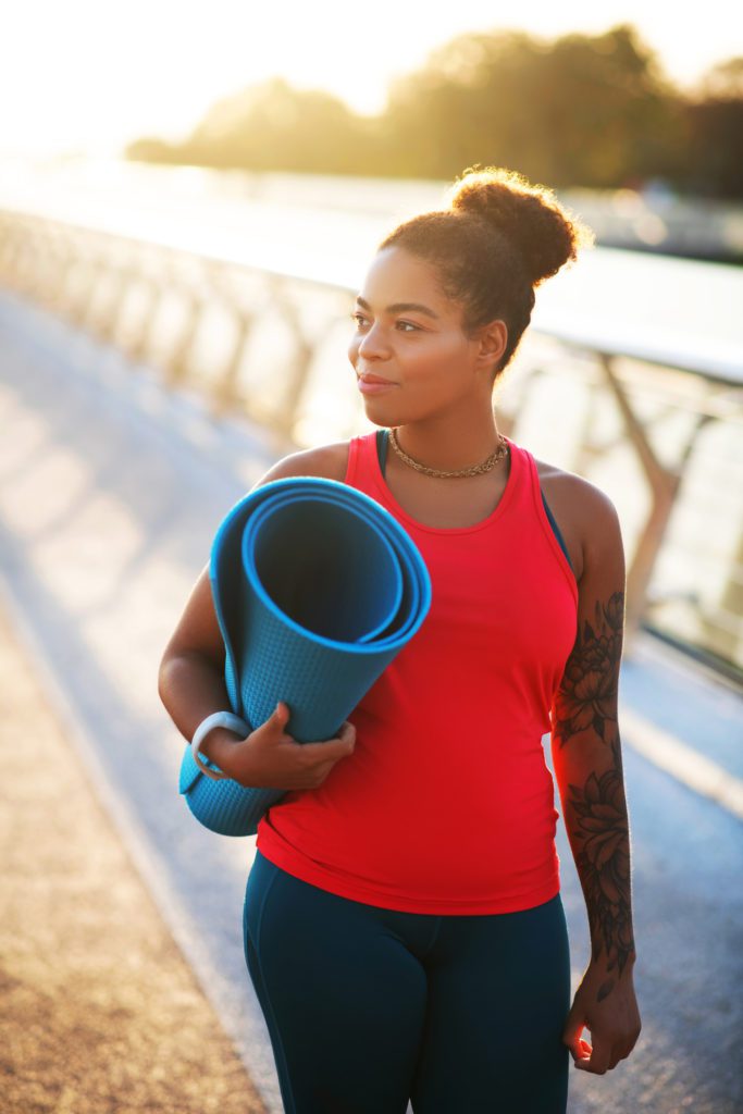 woman walking with yoga mat